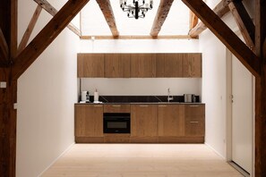 Eine moderne Küche mit Holzausstattung, einer schwarzen Arbeitsplatte und einem eingebauten Backofen.