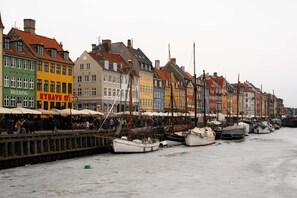 Ein Ufer mit bunten Gebäuden und vor Anker liegenden Booten.