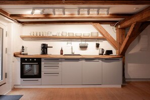 A compact kitchen with a built-in oven, a coffee maker, and a kettle on the countertop. - Apartment with Courtyard Access (København)