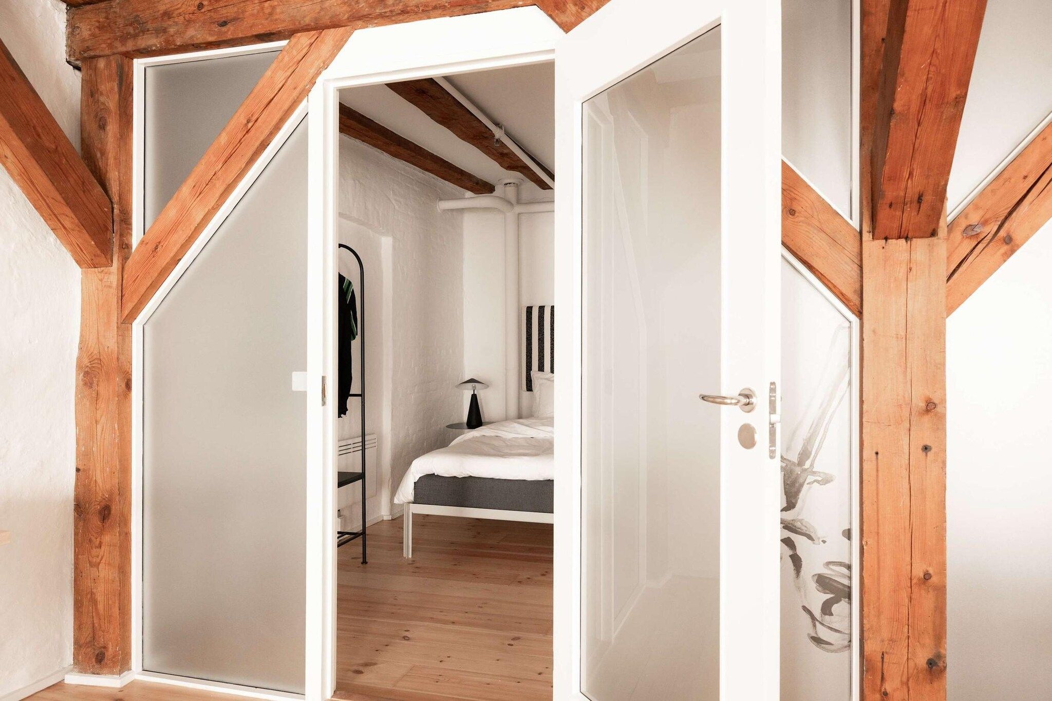 A room with a bed, a radiator, and a wardrobe.