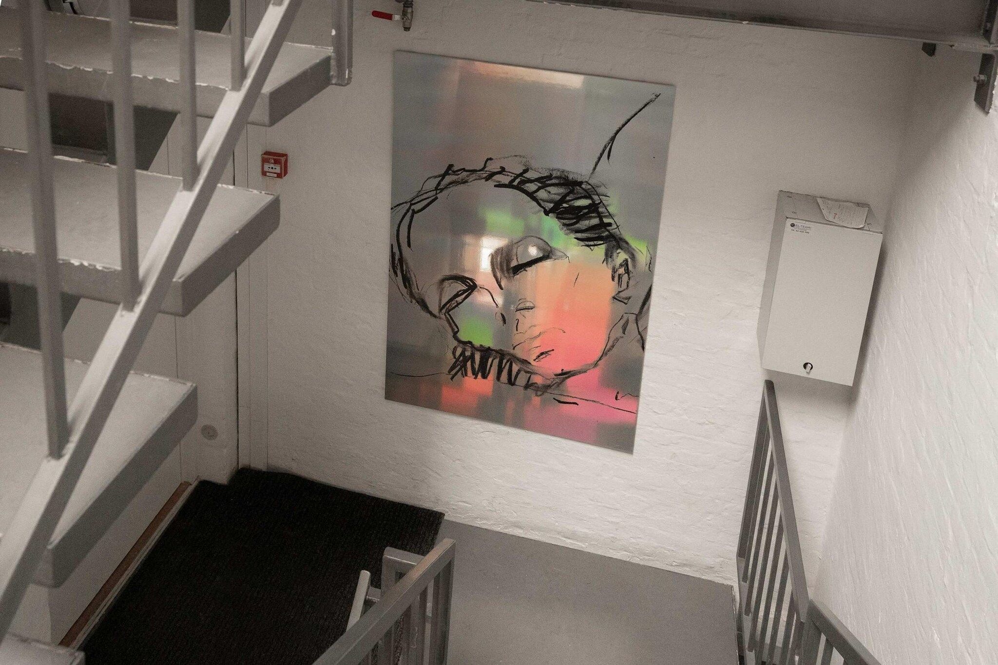 En trappa med ett konstverk som hänger på väggen.