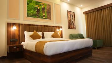 Una habitación de hotel con una cama grande, una silla verde y obras de arte en las paredes.