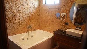 A bathroom with a bathtub, a vanity with a sink, and a towel rack.