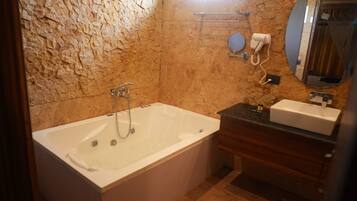 Een badkamer met een bad, een wastafelmeubel en een handdoekrek.
