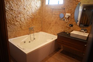 A bathroom with a bathtub, a vanity with a sink, and a towel rack.
