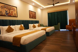 A hotel room with two beds, a ceiling fan, a large window with curtains, and artwork on the walls. - Onyxx Nature Resort (Chhoi)