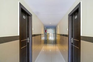 A corridor with doors labeled 206 and 203, leading to a bright interior space. - HILVON BUSINESS HOTEL (Bengaluru)
