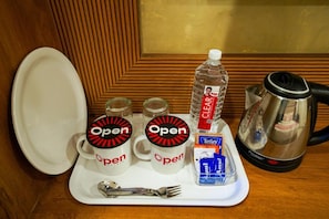A safata amb dues tasses de la marca 'Open', una ampolla d'aigua, una caixa de te Tetley, una cafetera i una cullera.