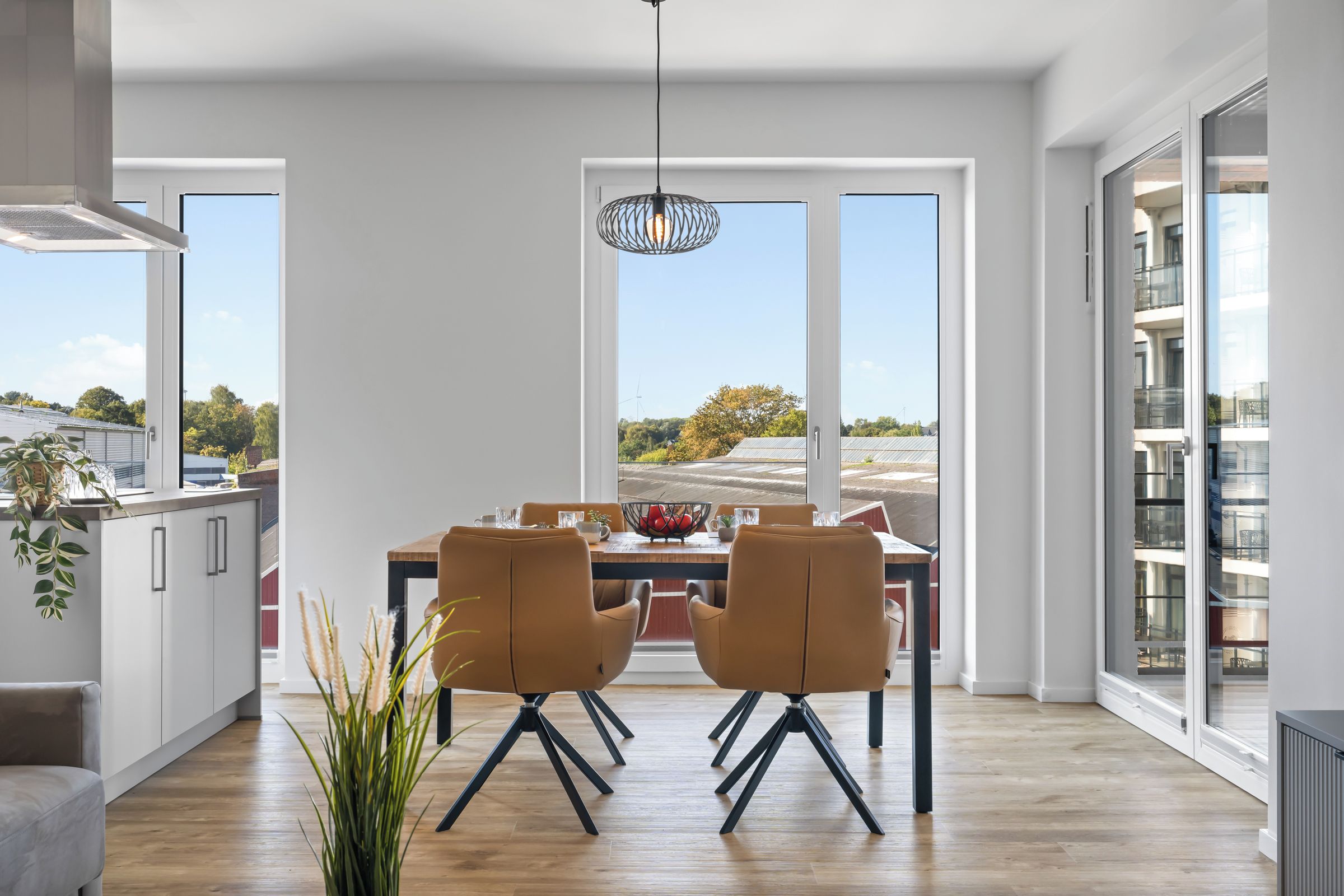 Een moderne eethoek met een groot raam, een eettafel en twee stoelen.