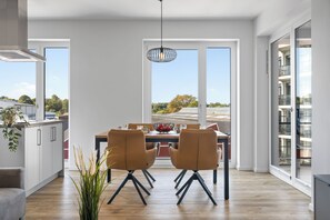 Et moderne spiseområde med et stort vindue, et spisebord og to stole.