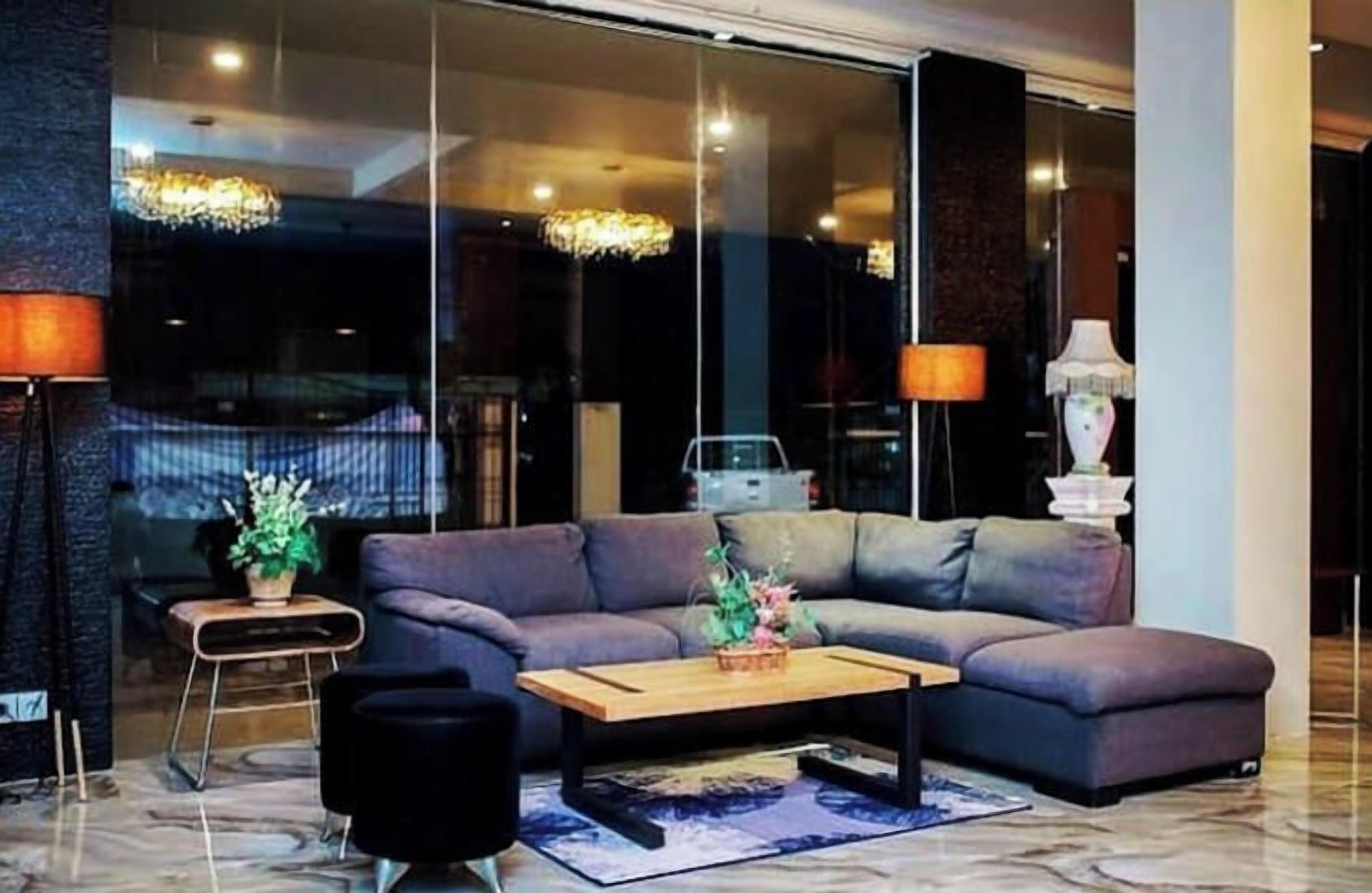 A modern living room with a sectional sofa, a coffee table, and a lamp.