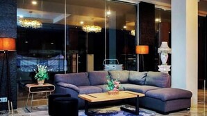 Una sala moderna con un sofá modular, una mesa de centro y una lámpara.