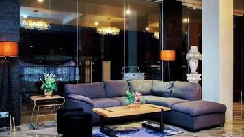 A modern living room with a sectional sofa, a coffee table, and a lamp.