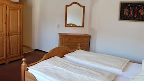 Ein Schlafzimmer mit einem hölzernen Bett, einem Schminktisch, einem Spiegel und einem Gemälde an der Wand.