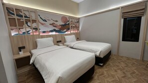 Habitació d'hotel amb dos llits, un panell de capçalera de fusta amb obra d'art, una petita taula de nit amb un telèfon i una finestra amb vistes.