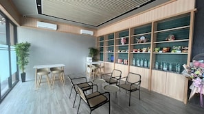 A modern interior with a seating area, a display of snacks, and a potted plant. - Hotel Kawa Samarinda Japanese Style (Samarinda)