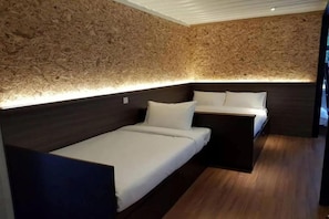 A room with a wooden textured wall, a bed with white bedding, and a bedside table. - Lilla Waterfall Retreat at Sg Lembing, Kuantan (Sungai Lembing)