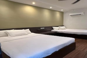 A hotel room with two beds, a wooden floor, and an air conditioning unit on the wall. - Lilla Waterfall Retreat at Sg Lembing, Kuantan (Sungai Lembing)