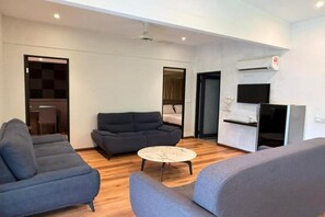 A modern living room with a sofa, a round coffee table, and a TV.