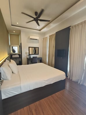 A hotel room with a large bed, a desk, a chair, a ceiling fan, and curtains. - Lilla Waterfall Retreat at Sg Lembing, Kuantan (Sungai Lembing)