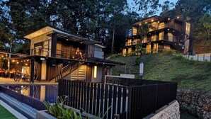 Un bâtiment moderne à deux étages, doté d’un balcon, d’un escalier et d’un espace piscine.