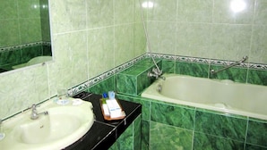 Un baño con lavamanos, espejo y bañera.
