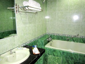 A bathroom with a sink, mirror, and bathtub. - Hotel Grand Duta Syariah Palembang (Palembang)