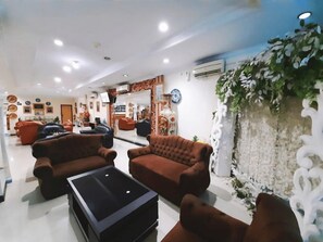 Eine Hotelhalle mit Sofas, einem Couchtisch und dekorativen Wandelementen.