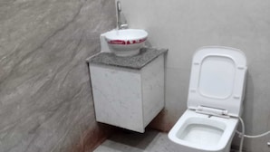 Un bagno con un water, un lavandino e una parete in marmo.