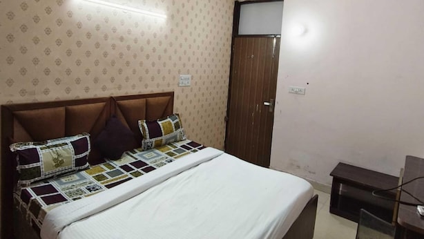 Una camera da letto con un letto, una ventola a soffitto, un armadio e una scrivania.