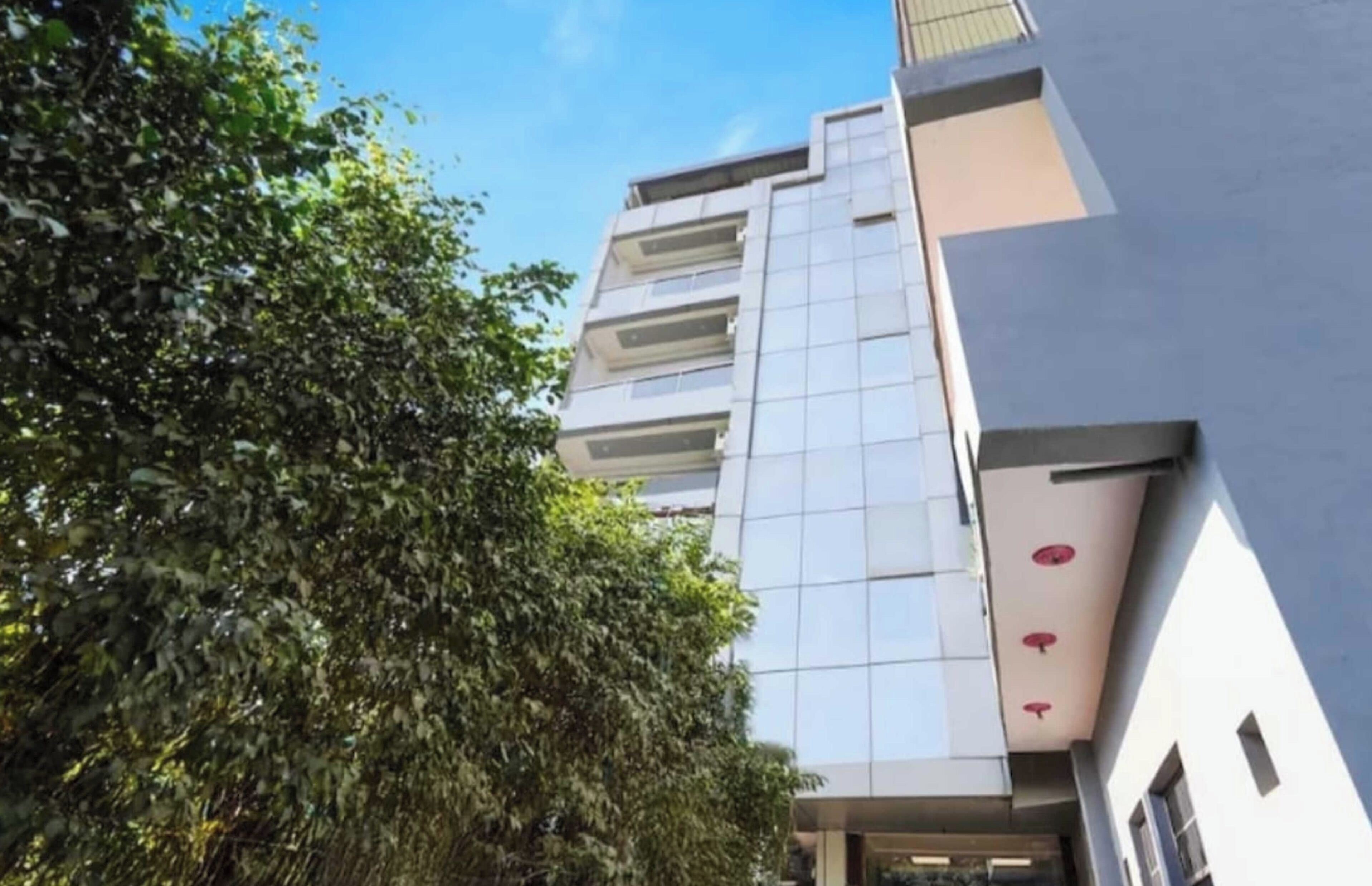 A modern building with a glass facade and multiple balconies.