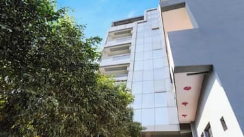 A modern building with a glass facade and multiple balconies.