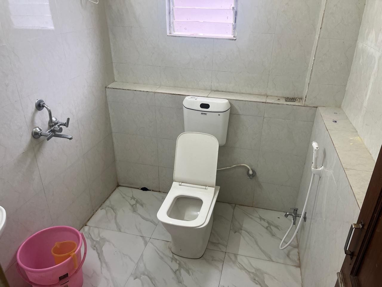 Ein kleines Badezimmer mit Toilette, Dusche und Waschbecken.