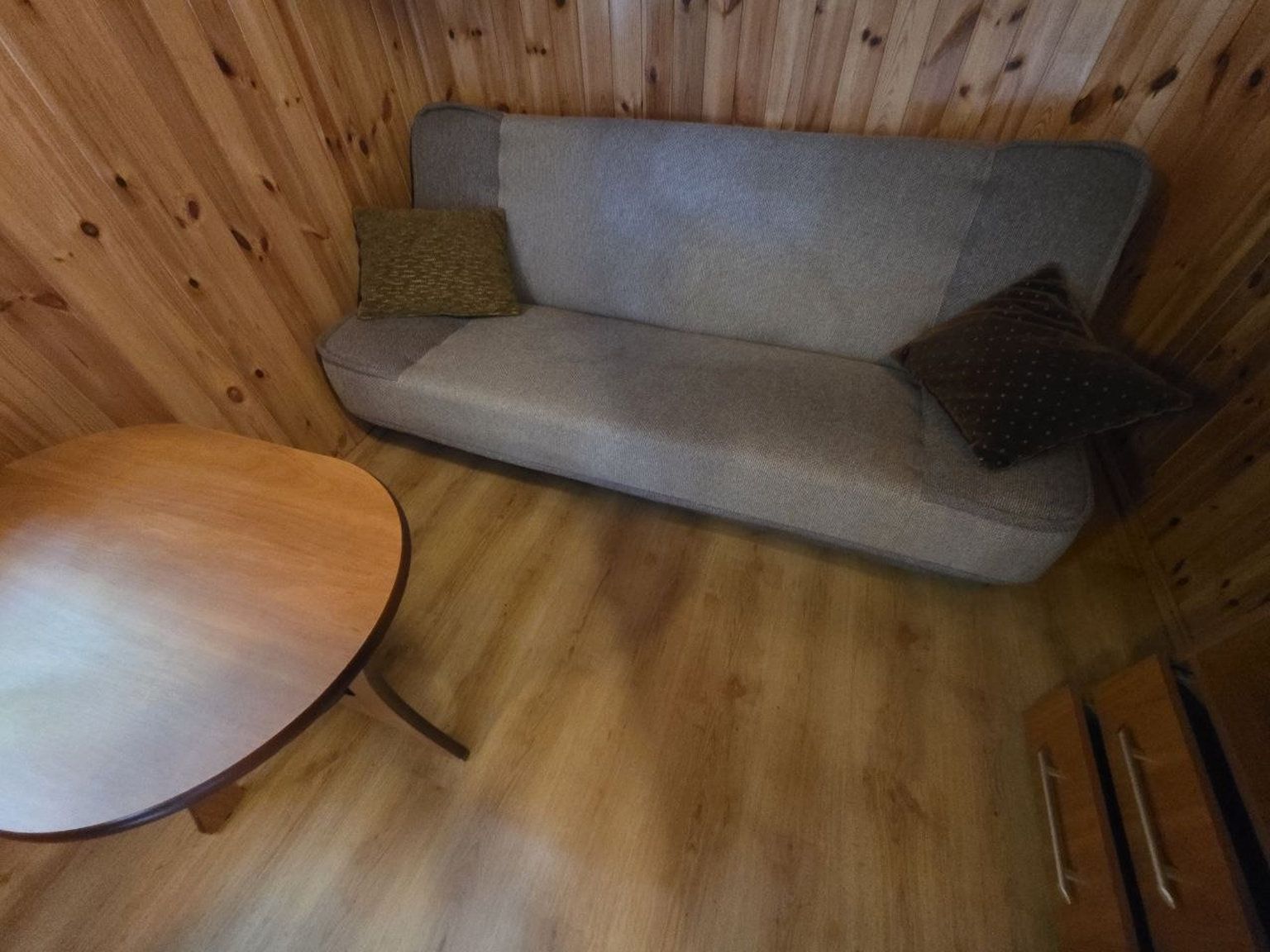 Un intérieur en bois avec un canapé et une table ronde.