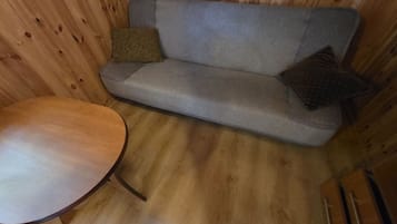 Un intérieur en bois avec un canapé et une table ronde.