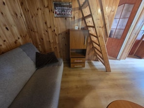 Un interior de madera con un sofá y un mueble de madera con cajones.