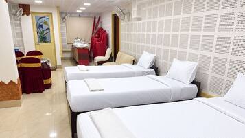 Habitación de hotel con dos camas, un escritorio, sillas y un adornado en la pared.