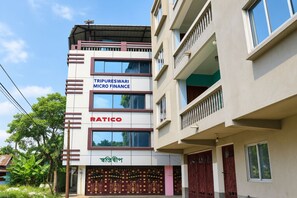 A multi-story building with signage for 'TRIPURESWARI MICRO FINANCE' and 'RATICO'. - Swastideep Homestay (Agartala)