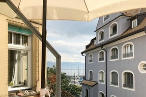Ein Balkon mit Blick auf einen Yachthafen und Berge im Hintergrund.