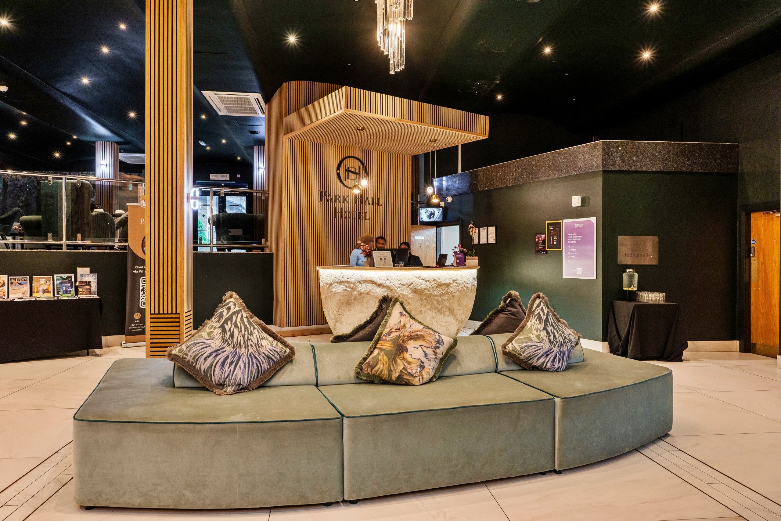 Un moderno vestíbulo de hotel con mostrador de recepción, zona de estar y un amplio ventanal.
