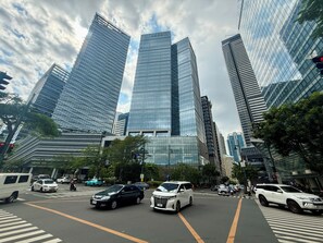 A city street with modern high-rise buildings, vehicles, and crosswalks. - Park McKinley West Tower-A Japanese Inspired Cozy Quiet 1BR Condo 85"HDTV 穏やかな (Taguig)