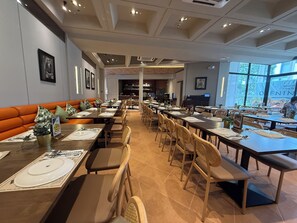 A restaurant with long tables, cushioned seating, and a view of the outdoors. - Park McKinley West Tower-A Japanese Inspired Cozy Quiet 1BR Condo 85"HDTV 穏やかな (Taguig)