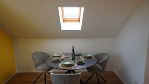 A dining area with a round table, two chairs, and a bottle of wine. - Honeygreen Apartment in Bodenheim with Pool, Terrace, and Wi-Fi (Bodenheim)