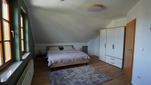 A bedroom with a bed, a wardrobe, a radiator, and a window. - Honeygreen Apartment in Bodenheim with Pool, Terrace, and Wi-Fi (Bodenheim)