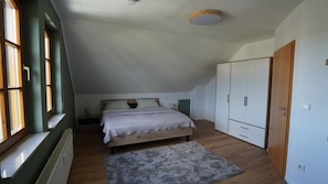 A bedroom with a bed, a wardrobe, a radiator, and a window. - Honeygreen Apartment in Bodenheim with Pool, Terrace, and Wi-Fi (Bodenheim)