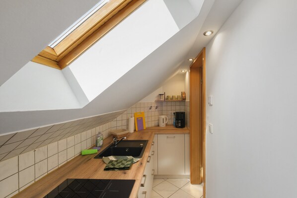 A modern kitchen with a skylight, a coffee maker, and a sink.