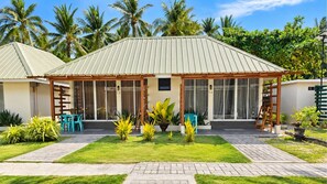 A two-story building with a flat roof, large windows, and a covered patio area with outdoor seating. - Dumaluan Beach Resort Panglao powered by Cocotel (Panglao)