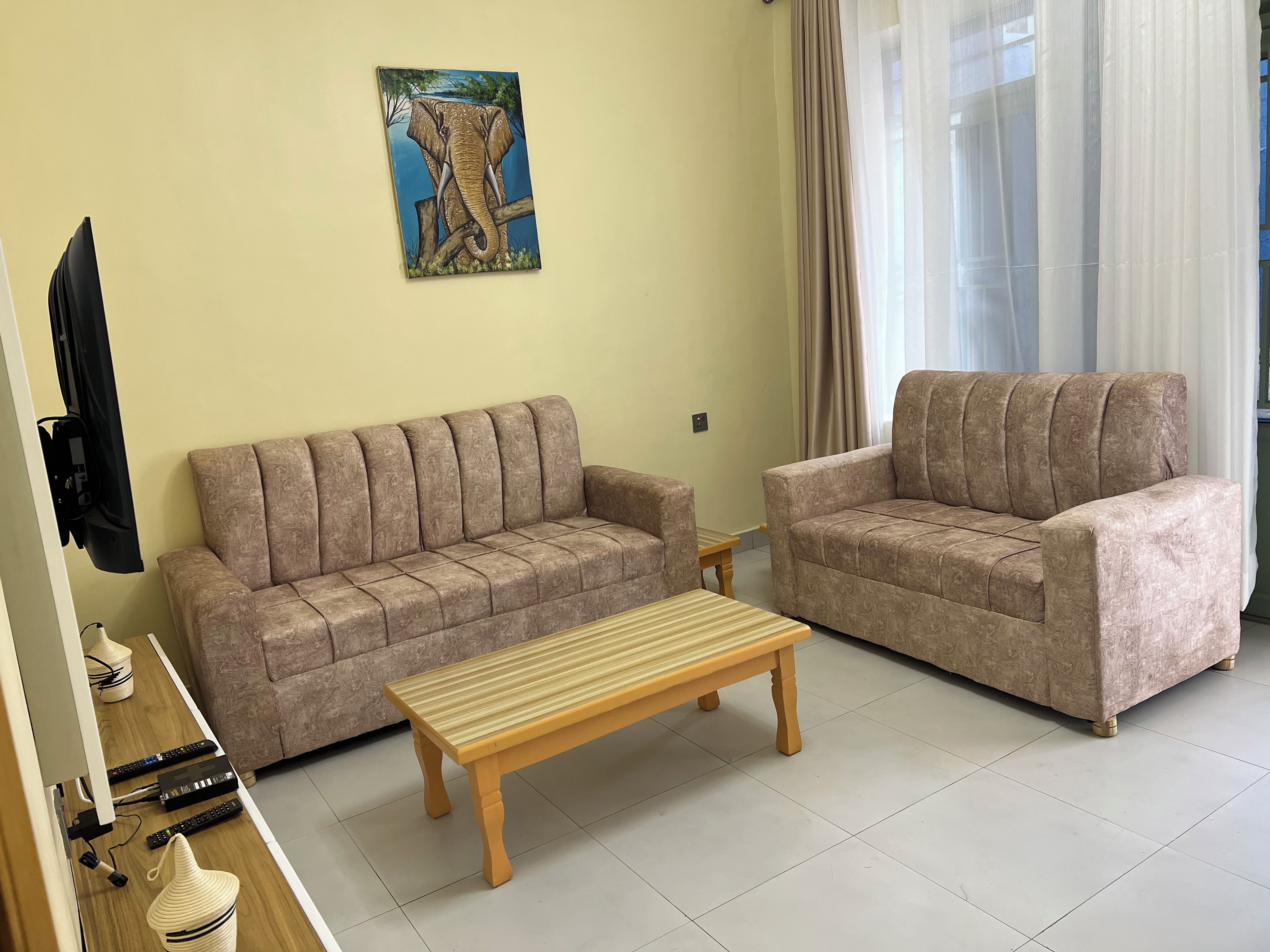 A living room with two sofas, a wooden coffee table, and a painting on the wall.