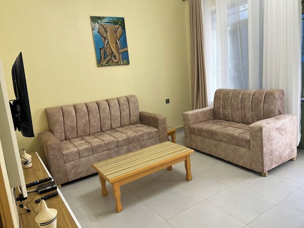 A living room with two sofas, a wooden coffee table, and a painting on the wall.