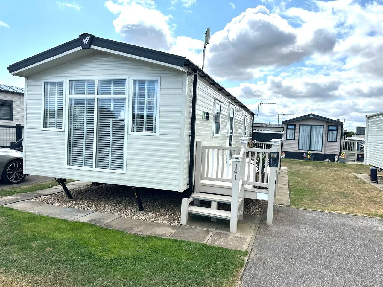 A mobile home with a porch and a small deck.